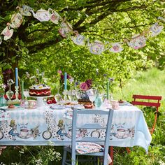 a table set up for a tea party in the woods