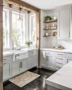 a kitchen with white cabinets and open shelves on the wall, along with an area rug