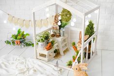 a doll house made out of fake plants and carrots is shown in the foreground