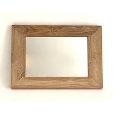 a wooden frame mirror hanging on the wall