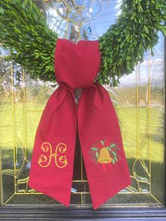 a red scarf with the letter h on it is hanging in front of a glass door