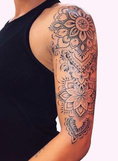 a woman's arm with an intricate tattoo design on her left arm and shoulder