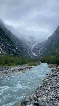 a river flowing through a valley surrounded by mountains