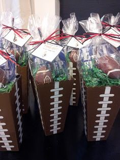 some paper bags filled with footballs on top of a table