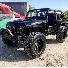 a black jeep parked on top of a dirt field