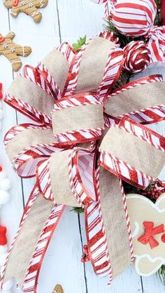 a close up of a christmas decoration on a white wooden table with candy canes