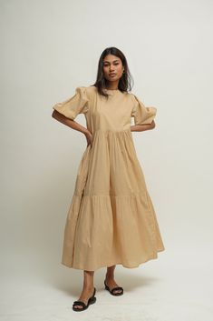 Experience freedom in our loose, tiered boho dress made from 100% organic cotton.  The boat neck combined with a key hole detailing at the back and the tiered skirt makes it perfect for the summer weather.  Features two inseam pockets and customizable colour options.  Length: 50 inches.  Quality: 60's Organic Cotton.  Care: Hand wash with light detergent or dry clean.  Ships within 3-5 business days. For quicker delivery please send us a message. Additional Information: Colour: Sand Beige Bed (C Flowy Beige Cotton Maxi Dress, Flowy Beige Linen Dress, Beige A-line Cotton Dress, Beige A-line Maxi Sundress, Beige A-line Linen Maxi Dress, Cotton Maxi Dress, Beige Bed, Layered Dress, Boho Tunics