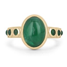 Featured is a stunning natural emerald cabochon unisex ring. This one-of-a-kind piece features a large 4.54-carat oval cut emerald cabochon as the center stone. It displays many good qualities and a lush medium-dark green color. Accenting the center stone are petite, round cut emerald cabochons on both sides of the shank. All gemstones are bezel set in a gleaming 14K yellow gold setting.  Setting Style: Bezel Setting Material: 14K Yellow Gold Gold Weight: 6.2 Grams Main Stone: Emerald Cut: Cabochon Shape: Oval Cut Weight: 4.54-Carats Clarity: Translucent Color: Green Luster: Very Good Treatments: Natural, Oiling Origin: Zambia Secondary Stone: Emerald Cut: Cabochon Shape: Round Cut Weight: 0.48-Carats (Total) Clarity: Translucent Color: Green Luster: Very Good Treatments: Natural, Oiling O Fine Jewelry Emerald Oval Cabochon Ring, Fine Jewelry Emerald Ring With Oval Cabochon, Heirloom Oval Cabochon Emerald Ring, Fine Jewelry Green Emerald Cabochon Ring, Fine Jewelry Green Cabochon Emerald Ring, Green Cabochon Emerald Ring Fine Jewelry, Yellow Gold Emerald Ring Oval Cabochon, Yellow Gold Emerald Ring With Oval Cabochon, Fine Jewelry Emerald Oval Cabochon Ring For May Birthstone