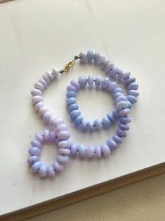 Our Candy Opal Pastel Necklace featuring purple to blue ombre colors Silk Knotted on 100% Silk Cord in Lilac, with 14K Gold Filled Finding and Lobster Clasp. Each beaded is hand placed for the best ombre effect, these smooth rondelle shaped opal beads and perfect for any spring/summer Boho Chic look. Great for gifts, birthdays, and celebrations.  Each Necklace comes with a custom handmade cotton dust bag. Necklace Info: Approximately 18 Inches Long Bead Size: 7.0 mm - 8.0 mm Smooth Rondelle Shap Purple Blue Ombre, Pastel Necklace, Bag Necklace, Pastel Ombre, Ombre Purple, Hand Beaded Necklace, Silk Necklace, Blue Candy, Gemstone Beaded Necklace