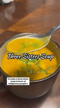 a spoon full of soup sitting on top of a wooden table