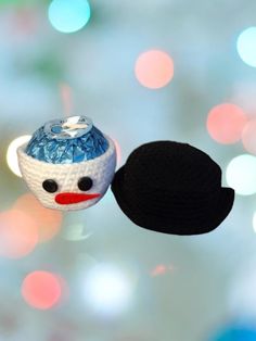 an ornament with a black hat on it and a red nose is hanging from a string