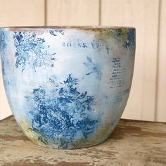 a blue and white bowl sitting on top of a wooden table next to a wall