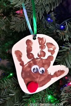 a handprint ornament hanging from a christmas tree