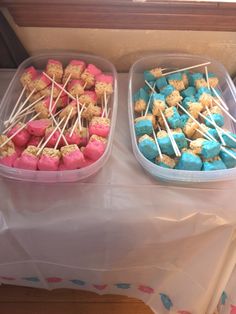 two plastic containers filled with marshmallows and pretzels on skewers