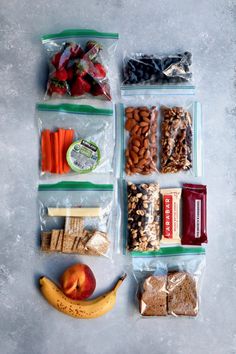 an assortment of snacks and fruits are laid out on the table to be packed up