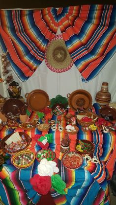 a colorful table cloth covered with plates and bowls