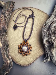 Tribal style necklace with a rounded-shaped Flower Jasper cabochon of 1.5 cm in diameter, with pink and red veins on a light background. Setting and processing in Micro Macramé technique, made of natural earthy shades of dark purple and mustard. Waxed polyester threads. Embellished and adjustable cord with sliding knot closure. With the addition of nickel-free brass beads. Ornament Gift Woman. Flower Jasper stone helps to reconnect with the Earth element, encouraging action. It brings resolve an Macrame Jewelry With Round Beads For Gifts, Pink Macrame Jewelry As A Gift, Bohemian Brown Medallion Necklace, Festival Macrame Pendant Necklace, Unique Macrame Pendant Necklace, Bohemian Round Jewelry With Adjustable Length, Bohemian Handmade Round Pendant Necklace, Macrame Necklaces With Round Beads As Gift, Cabochon Amulet Pendant Necklace