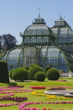 a large glass house with many flowers in the front