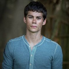 a young man in a blue shirt is posing for the camera