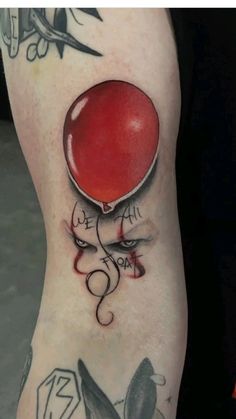 a person with tattoos on their legs has a red balloon