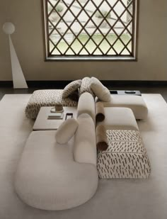 a large white couch sitting in front of a window