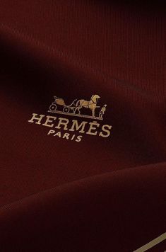 there is a horse drawn carriage on the side of this maroon shirt that says hermes paris