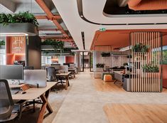 an office with wooden partitions and plants on the walls, along with desks