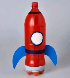 a red rocket ship shaped paper toy on a gray background