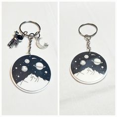 two key chains that have pictures of planets and stars on them, one with an astronaut's head in the middle