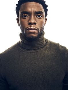 a man in a turtle neck sweater looking at the camera with an intense look on his face