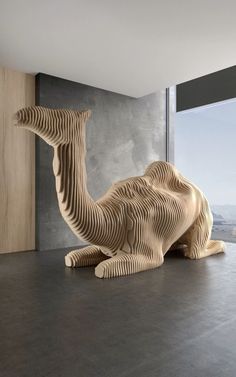 a wooden sculpture sitting on top of a floor next to a window