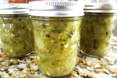 three jars filled with pesto sitting on top of a counter