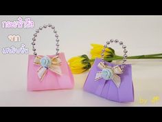 two small bags with bows on them are sitting next to each other, one is purple and the other is pink