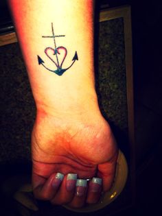 a woman's foot with an anchor and heart tattoo on it