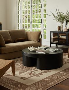 a living room with a couch, coffee table and large window in the back ground