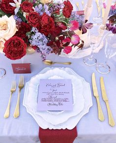 the table is set with flowers and silverware