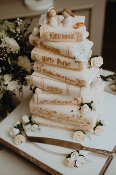 a wedding cake is stacked on top of each other with books as the bride and groom's names