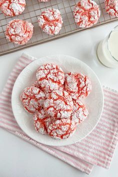 powdered sugar cookies on a plate next to a cooling rack