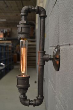 an industrial style light fixture hanging from the side of a building