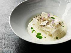 a white bowl filled with food on top of a table