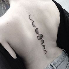 the back of a woman's neck with phases of the moon tattoo