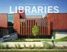 the building has many windows and is made out of wooden slats, with grass in front of it