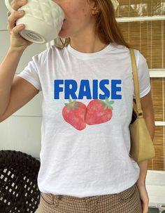 Add a pop of color to your summer wardrobe with this Strawberry Fraise Women's Baby Tee. This fitted short-sleeve crop top is made from soft cotton, offering a comfortable and breathable feel that's perfect for casual wear or layering. Its soft red color brings energy and vibrancy to any outfit, making it ideal for those who love bright colors.  The baby tee style features a close fit, giving it a trendy and y2k, early 2000s look. It's versatile enough to pair with high-waisted jeans, skirts, or Fitted Fruit Print Summer Tops, Red Fruit Print Tops For Summer, Red Fruit Print Top For Spring, Summer Strawberry Print Short Sleeve Tops, Retro Spring Top With Strawberry Print, Retro Spring Tops With Strawberry Print, Red Strawberry Print Top For Summer, Fitted Strawberry Print Short Sleeve Tops, Fitted Short Sleeve Top With Strawberry Print