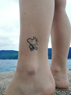 a person with a small tattoo on their foot near the water's edge,