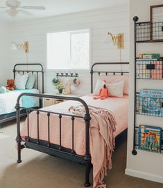 a bedroom with two twin beds and a book shelf on the wall next to them