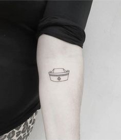 a woman's arm with a small boat tattoo on the left side of her arm