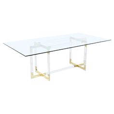 a glass table with gold legs on a white background