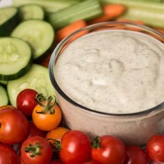 cucumbers, tomatoes, and celery are arranged around a dip