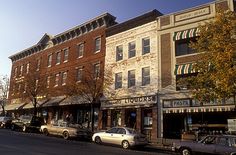 several cars are parked on the street in front of some buildings with awnings