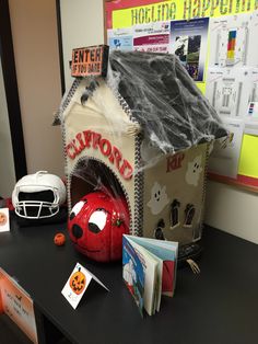 an office desk with halloween decorations on it and a book case in the shape of a dog house